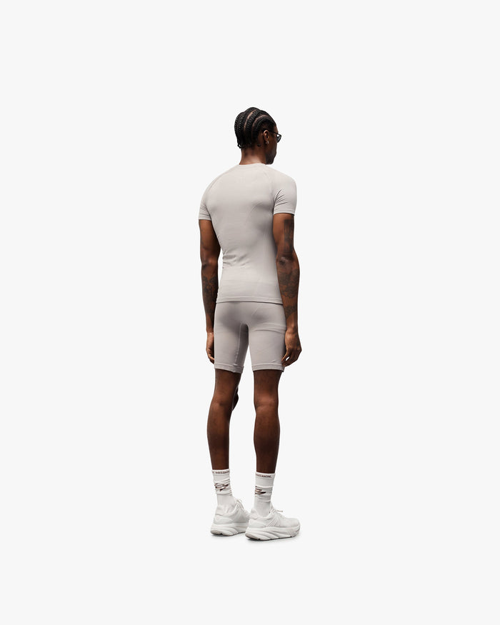 Man wearing a grey performance t-shirt on a plain white background | 247 DNA Seamless T-Shirt in Titanium | Seamless t-shirt with engineered knit zones | 247 T-Shirts | Represent Clo