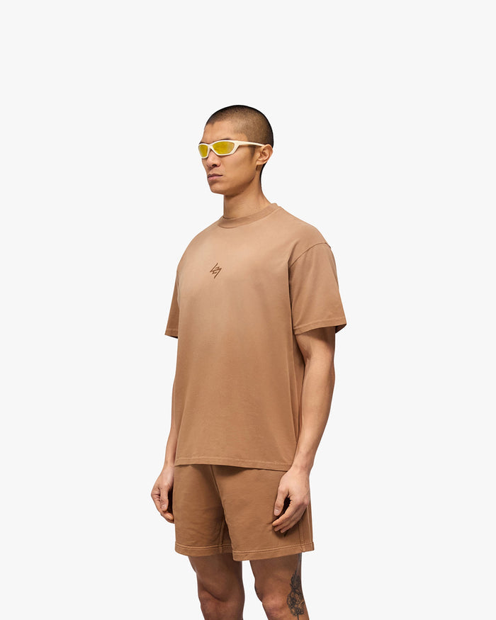Man wearing a rust oversized t-shirt on a plain white background | 247 Motion Oversized T-Shirt in Rust | Oversized t-shirt with graphic print | 247 T-Shirts | Represent Clo