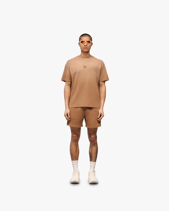 Man wearing an oversized rust t-shirt on a plain white background | 247 Motion Oversized T-Shirt in Rust | Comfortable t-shirt with 2 way stretch and graphic print | 247 T-Shirts | Represent Clo