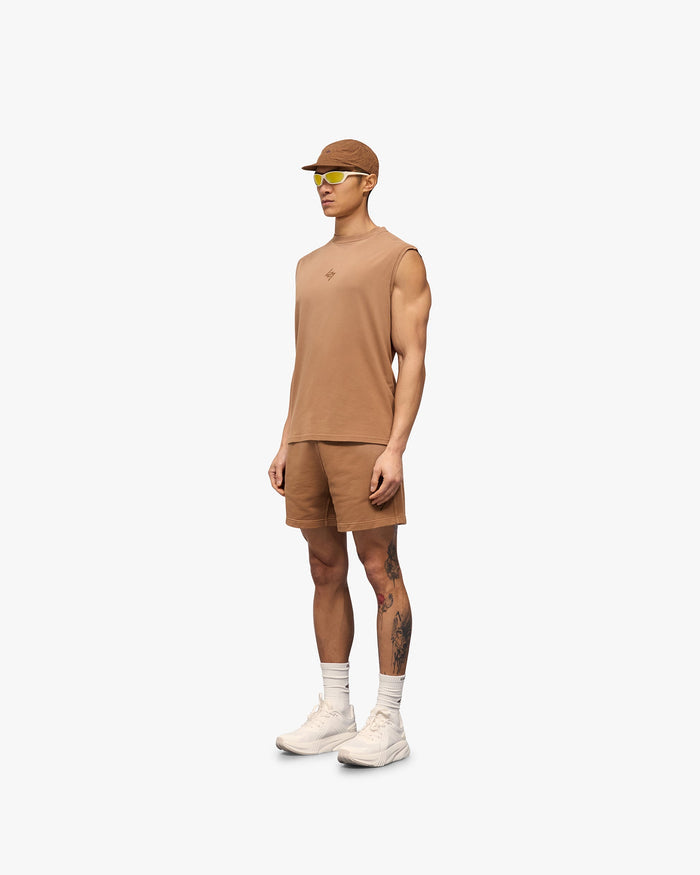 Man wearing an oversized rust tank on a plain white background | 247 Motion Oversized Tank in Rust | Oversized tank with water based graphic print | 247 T-Shirts | Represent Clo