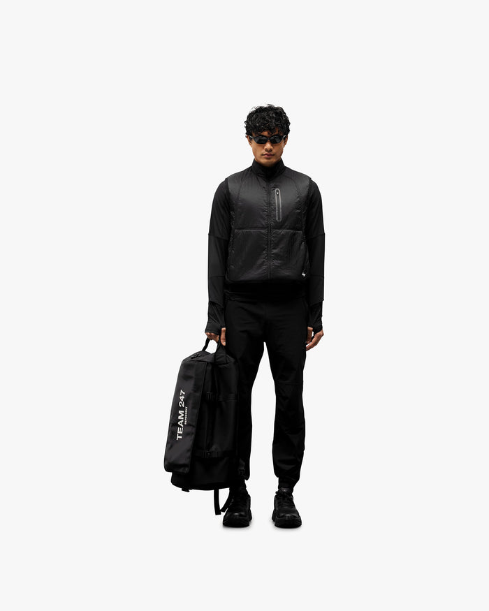Man wearing a black gilet on a plain white background | 247 Run Gilet in Black | Performance running gilet with insulation and zip pockets | 247 Outerwear | Represent Clo