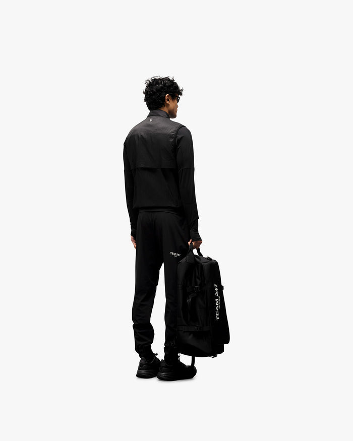 Man wearing a black gilet on a plain white background | 247 Run Gilet in Black | Performance running gilet with insulated front and zip pockets | 247 Outerwear | Represent Clo