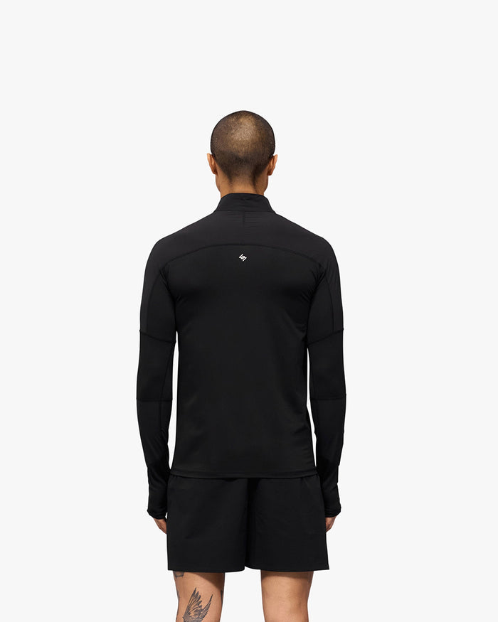 Man wearing a black quarter zip outerwear on a plain white background | 247 Run Quarter Zip in Jet Black | Performance outerwear with mesh panels and thumb holes | 247 Outerwear | Represent Clo