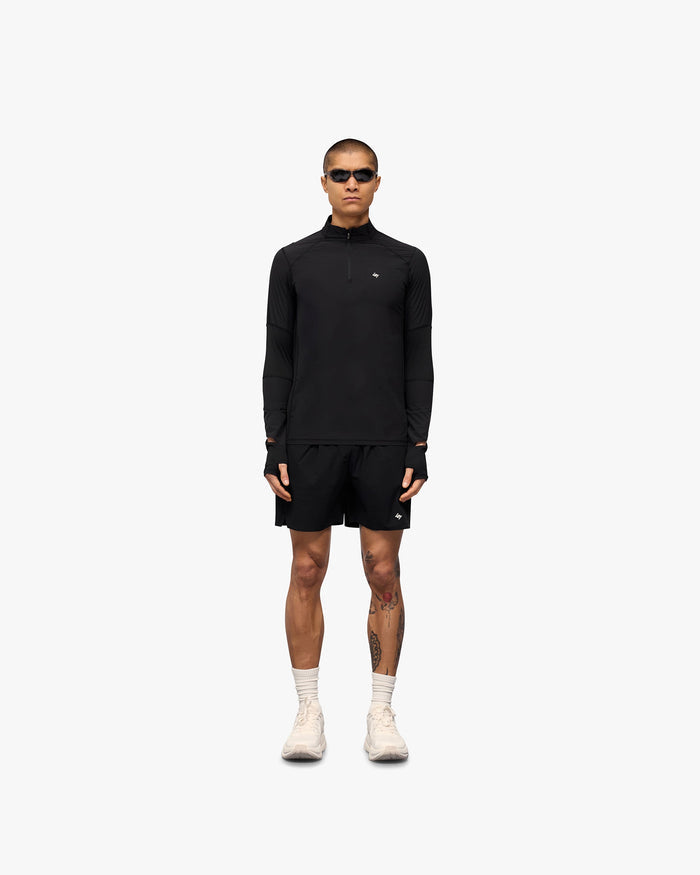 Man wearing a black quarter zip on a plain white background | 247 Run Quarter Zip in Jet Black | Outerwear with mesh panel inserts and thumb holes | 247 Outerwear | Represent Clo