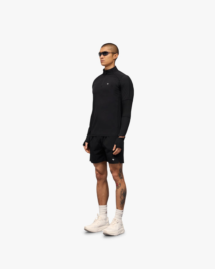 Man wearing a black quarter zip on a plain white background | 247 Run Quarter Zip in Jet Black | Outerwear with mesh panel inserts and thumb holes | 247 Outerwear | Represent Clo