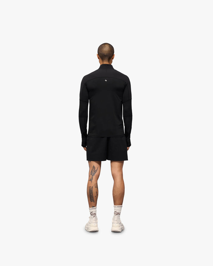 Man wearing a black quarter zip on a plain white background | 247 Run Quarter Zip in Jet Black | Outerwear with mesh panels and thumb holes | 247 Outerwear | Represent Clo