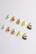 Press-on nails with cute capybara art by Alice Lee. Features peach, blue, green nails with capybaras and fruit.