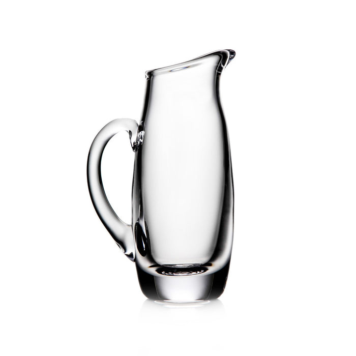Clear glass pitcher with curved handle and tapered pouring spout on white background.