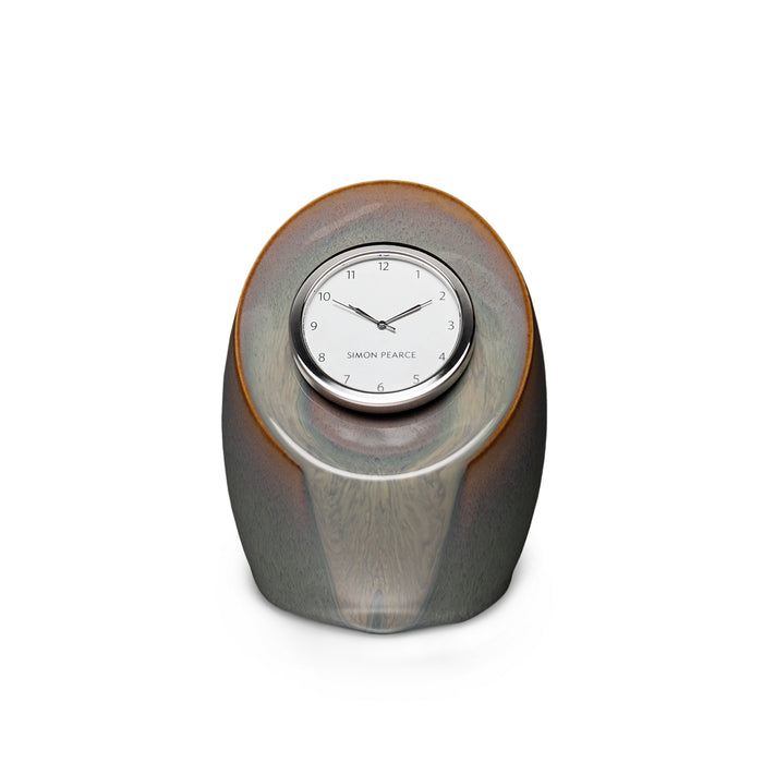 Gray pottery clock with rounded oval shape and embedded circular clock face with numerals and Simon Pearce branding.
