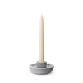 Gray soapstone candle holder with a cream taper candle inserted in the center socket.