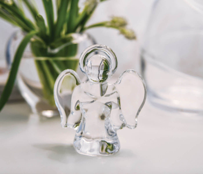 Clear glass angel figurine with wings and halo, small size, displayed on white surface.