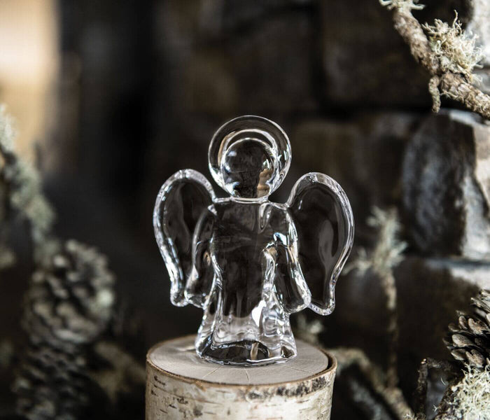 Clear glass angel figurine with wings and halo on wooden base.