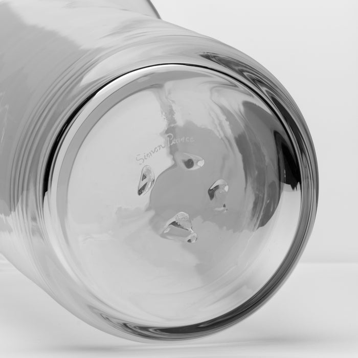 Clear glass pitcher with textured ribbed body and pouring spout, viewed from the front.