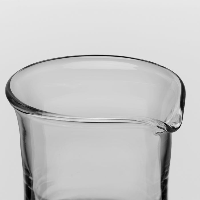 Clear glass pitcher with angled spout and rolled rim for pouring.