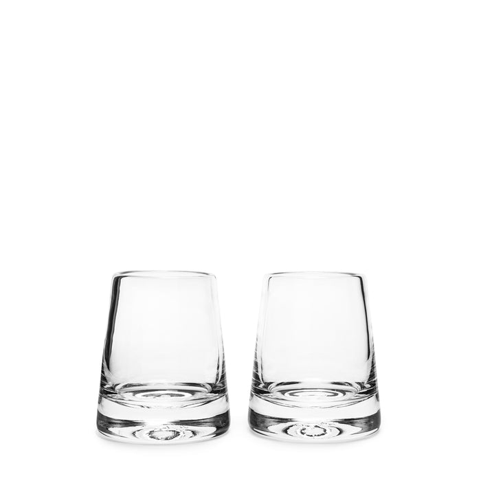 Two empty clear glass tumblers with thick bases side by side.