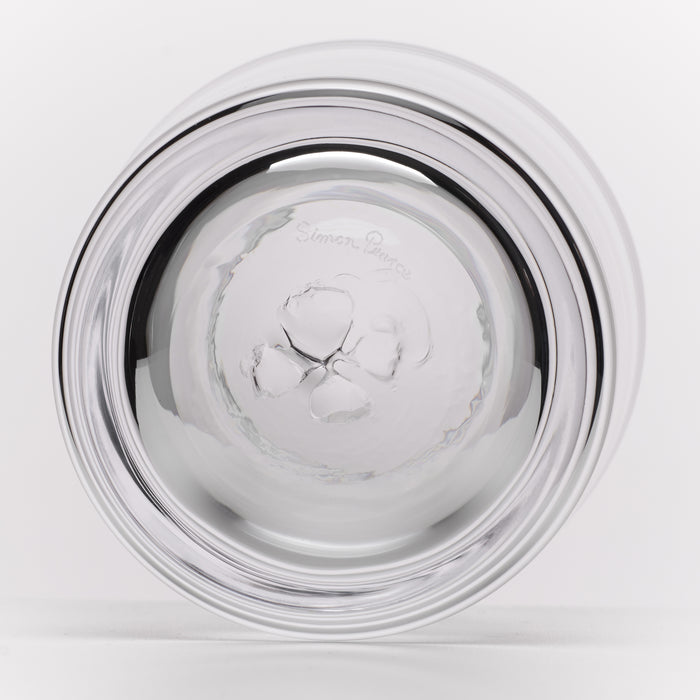 A round, clear glass with a wide, flared rim, photographed from the bottom on a clean white background. The bottom of the glass features a subtle brand logo and a faint 'Simon Pearce' brand signature near the top.
