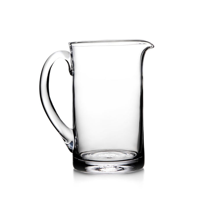 Clear glass pitcher with curved handle and pouring spout.