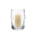 Clear glass hurricane with twisted sides holding a lit cream-colored pillar candle.