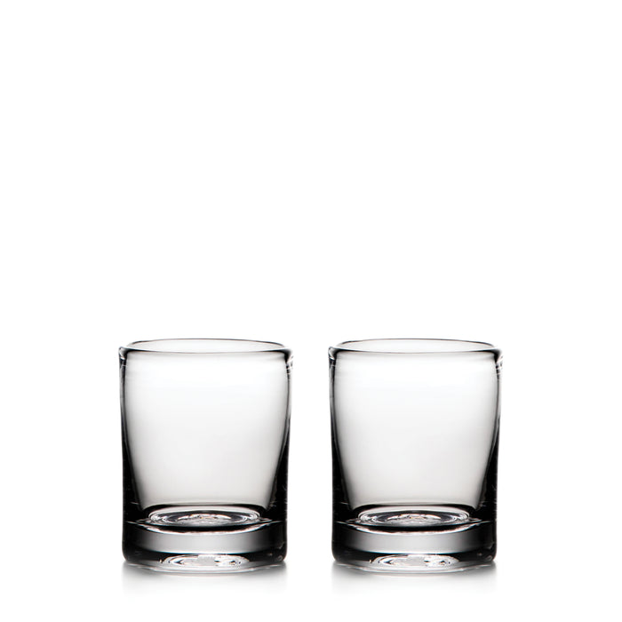 Two clear glass whiskey glasses with thick bases, empty and positioned side by side.