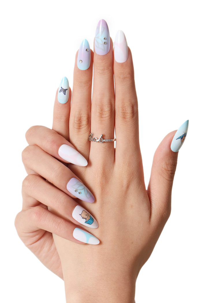 Aura Kewpie press-on nails with pastel ombre, butterfly, and Kewpie baby designs.