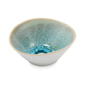 White ceramic cereal bowl with blue-green glazed interior and natural rim, angled view.