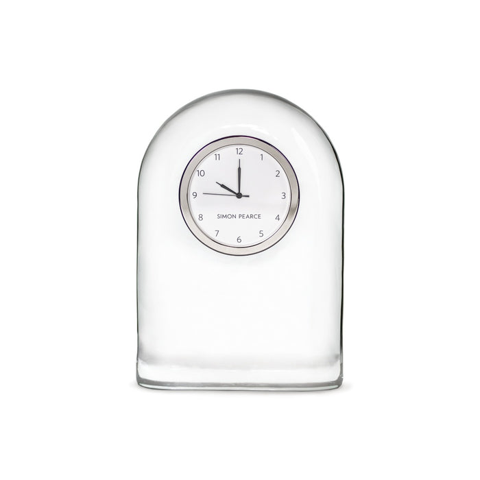 Clear glass dome-shaped clock with circular face displaying numbers and "Simon Pearce" branding.
