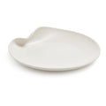 White ceramic platter with organic curved shape and small handle indent on one side.