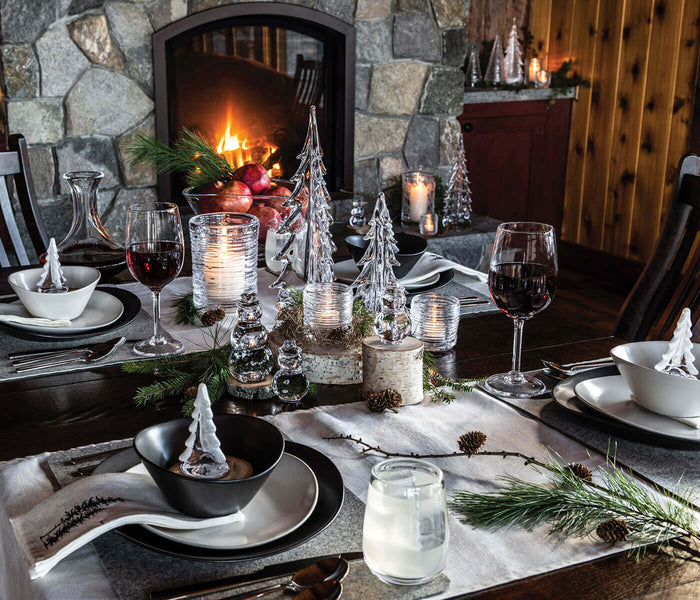 White ceramic serving bowl with curved sides displayed on a festive dining table setting.
