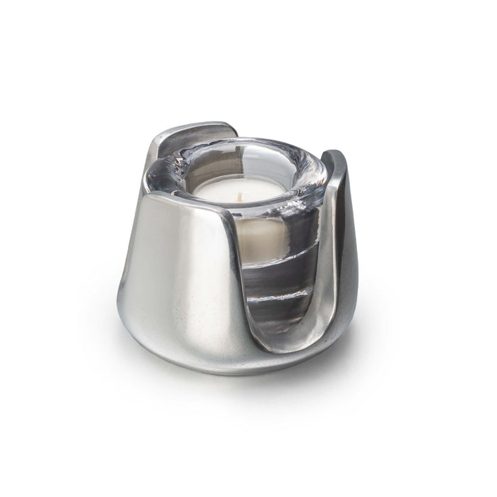 Silver metallic tealight holder with glass insert containing a cream-colored candle and visible wick.
