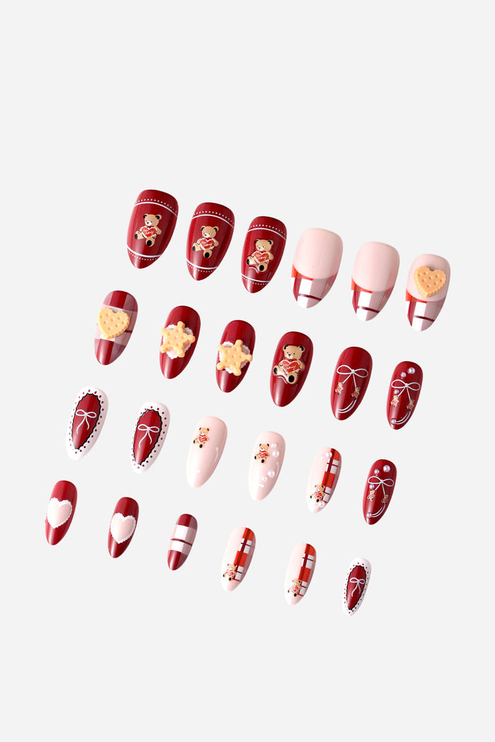 Almond press-on nails in red and pink featuring teddy bears, hearts, bows, and plaid patterns.