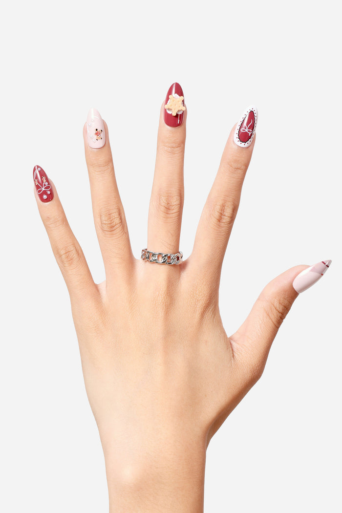 BEAR YUMMY almond press-on nails with cute festive designs including a bear, snowflake, and bow.