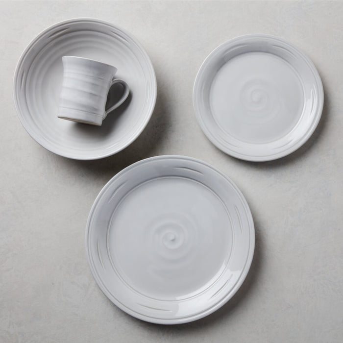 Three-piece Belmont dinnerware set in dove gray including one mug with black handle and two plates with concentric ring patte