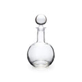 Clear glass decanter with a rounded body, narrow neck, and spherical stopper.