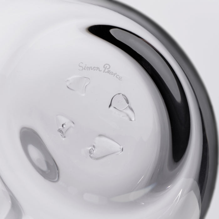 White glass decanter with black curved handle and etched branding on the body.