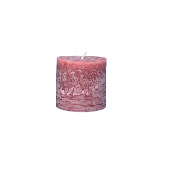 Mauve and pink pillar candle with textured surface and white wick on top.