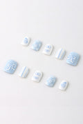 Blue Belle by Elaine Lee press-on nails with bow and floral designs in pastel blue and white.