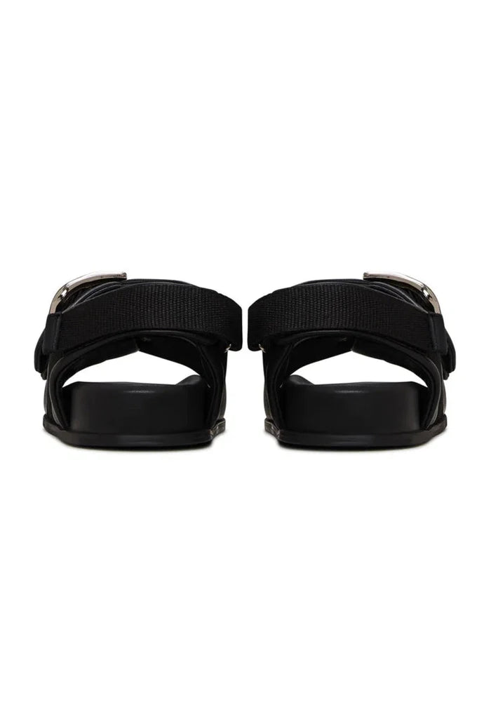 A stylish pair of black wedge sandals with bold buckle details, perfect for any summer outfit. Ideal women's shoes for a chic and trendy look.