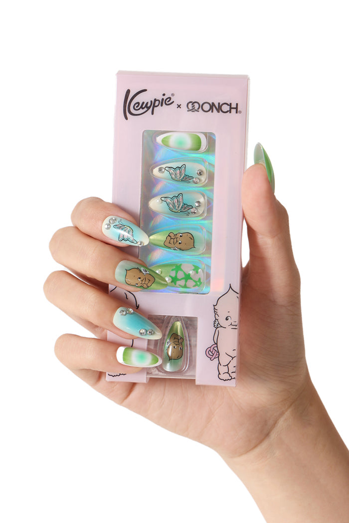 Bratty Kewpie press-on nails: pastel green/blue ombre with Kewpie character and butterfly designs, adorned with rhinestones.