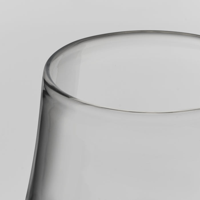 Close-up of a clear glass tumbler showing the rim and upper body against a light gray background.