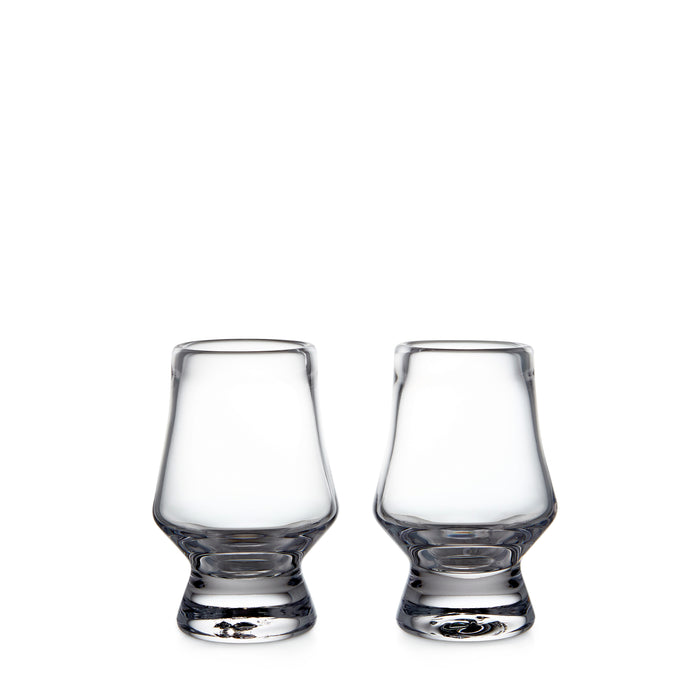 Two clear glass tasting glasses with tapered bowls and weighted bases.