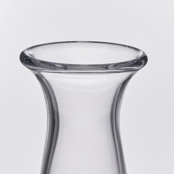 Clear glass decanter with curved sides and flared rim opening.