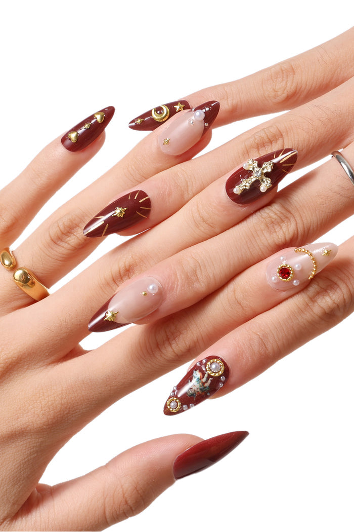 Burgundy French tip press-on nails with cherub and celestial designs, featuring pearls and gold accents.