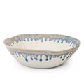 Ceramic pasta bowl with blue and gray brushstroke pattern on cream background and textured rim.