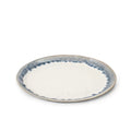 Round plate with cream center and blue brushstroke rim pattern on gray stoneware.
