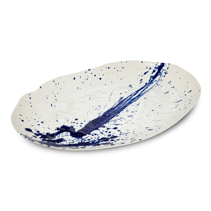 Large oval platter with cream glaze and blue splatter and speckle pattern throughout.