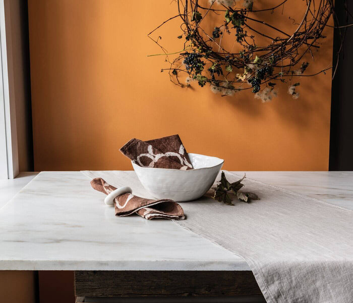 White ceramic serving bowl with curved sides on a marble surface.