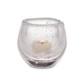 Clear glass tealight holder with cream-colored tealight candle inside.