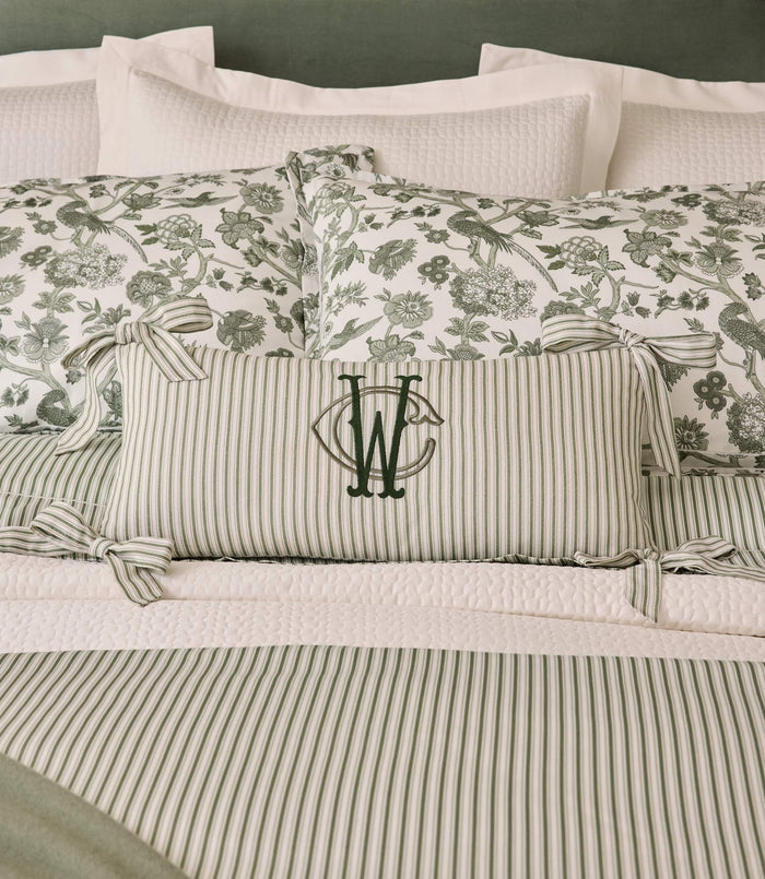 Caitlin Oblong Pillow monogrammed on a green bed, Stripe Moss