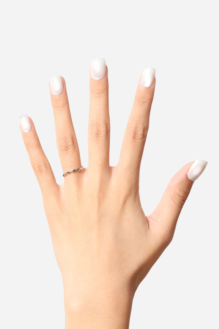 Hand displaying clean, glossy white square press-on nails and a delicate silver ring.