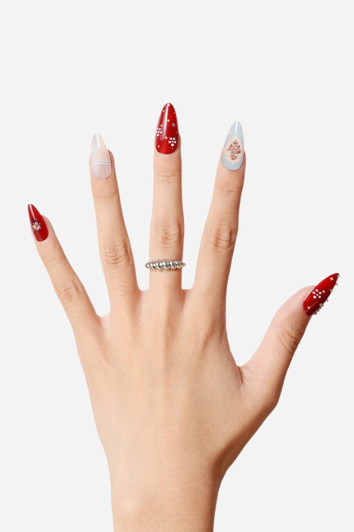 Almond press-on nails with red, white, and blue designs featuring floral patterns and a cat collage.